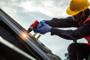 Homeowner inspecting roof shingles with binoculars while a ladder and gutter tools rest nearby.